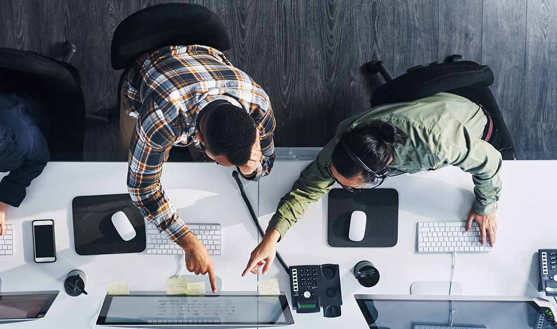 2人の同僚がコンピュータで協力して作業しています。